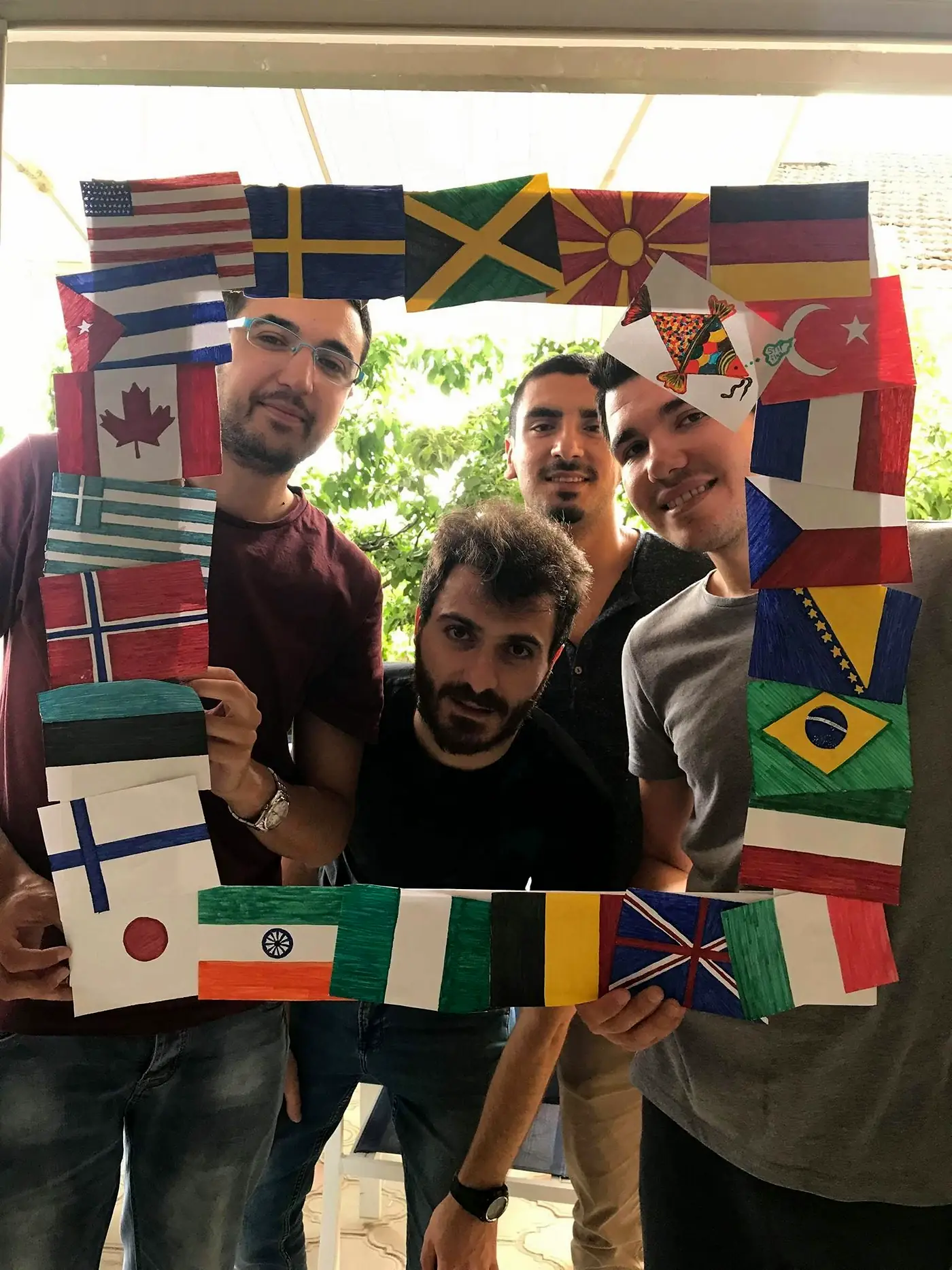 Participants holding a frame of hand-painted national flags made during an EVEC youth exchange